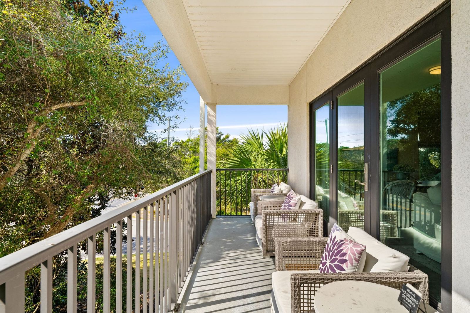 Private balcony with lounge seating overlooking the trees